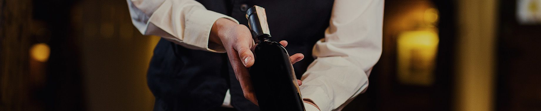 Close Up von einem Kellner, der gerade einen edlen Wein einschenkt