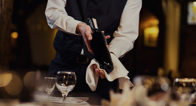 Close Up von einem Kellner, der gerade einen edlen Wein einschenkt